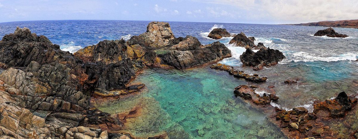 The Conchi natural pool ringed by volcanic rock inside Arikok National Park in Aruba