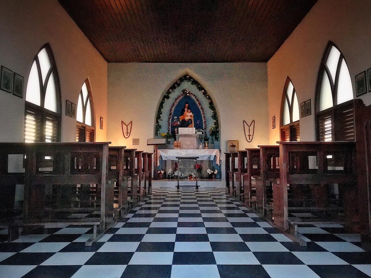 Inside Alto Vista Chapel, Aruba, with its checkerboard floor, wooden pews and altar