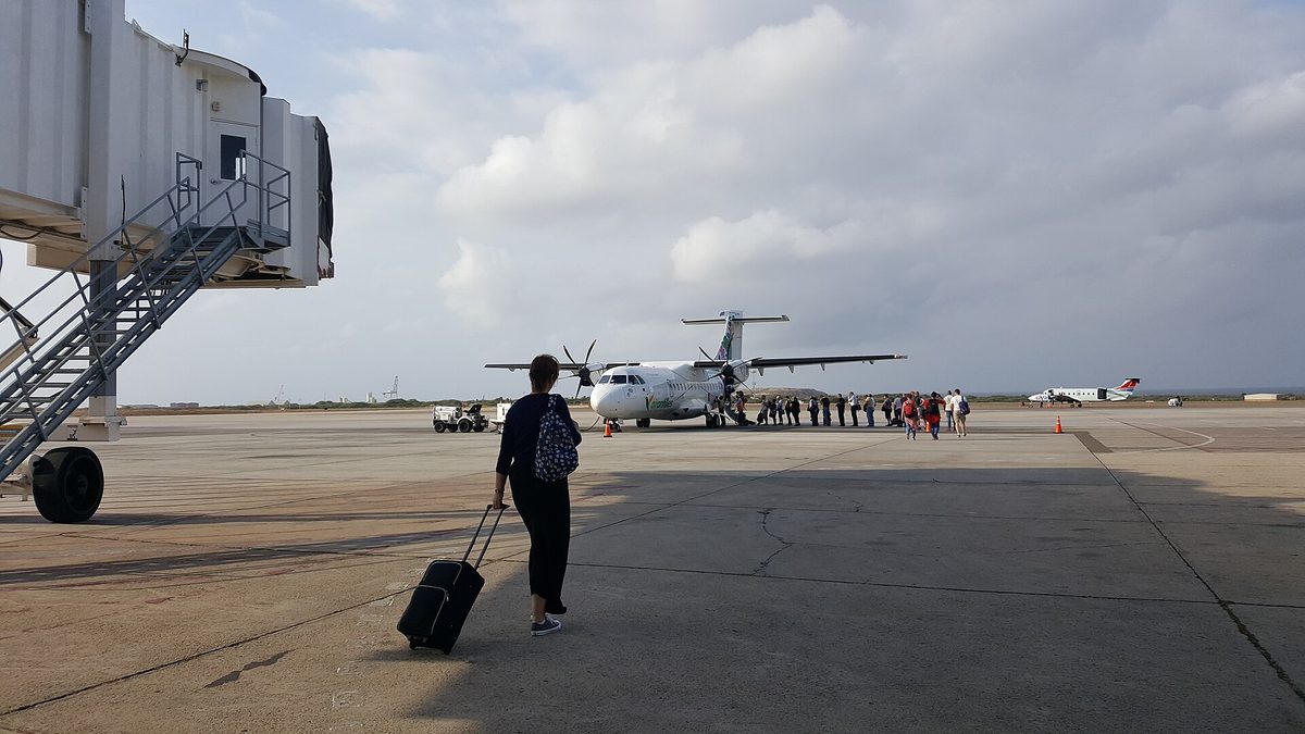 Traveler arriving at Aruba's Reina Beatrix airport, ready to buy a local SIM card and get online