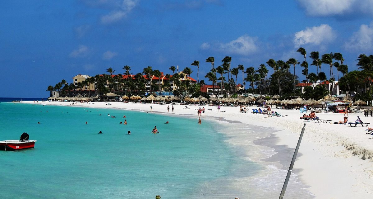 A quiet white-sand beach with shade palapas in Aruba