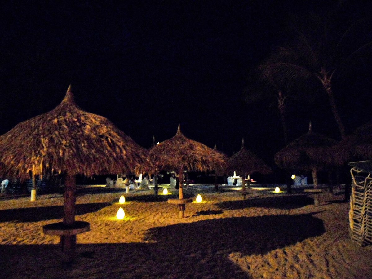 Thatched palapa on an Aruba beach at sunset, a romantic spot for couples