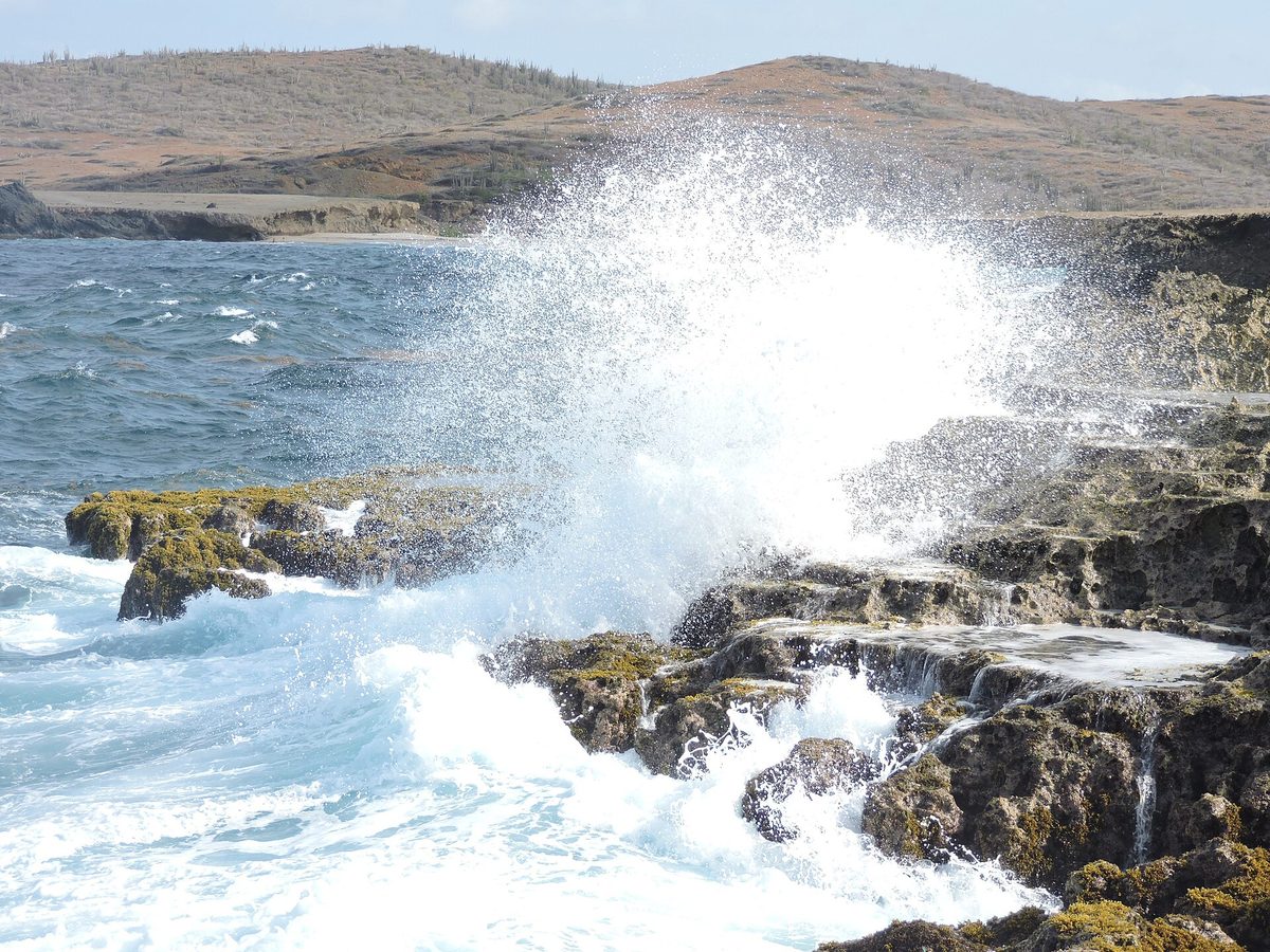 Waves breaking on the rugged turquoise coastline of Aruba