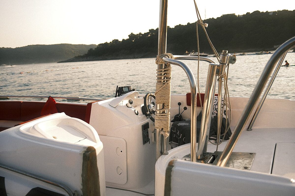 The deck of a sailing catamaran at golden hour on a calm Caribbean sea