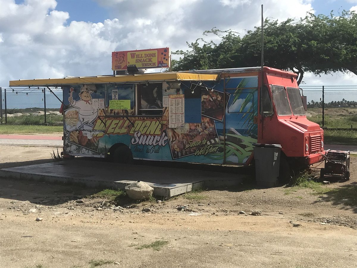 A colorful food truck in Aruba serving cheap local snacks