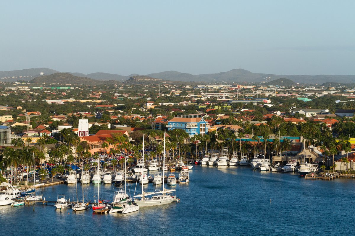 Yachts and boats moored in the Oranjestad marina, where waterfront restaurants line the Aruba harbor