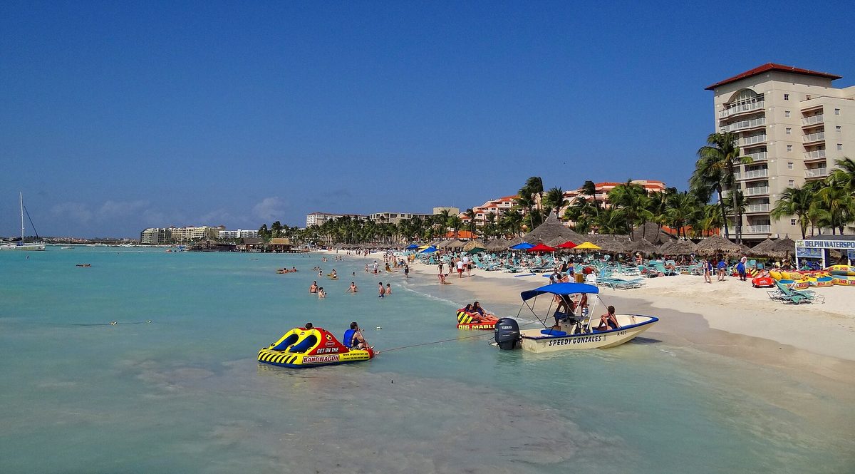 Calm turquoise water, soft sand and palapas at Palm Beach, Aruba's main resort strip