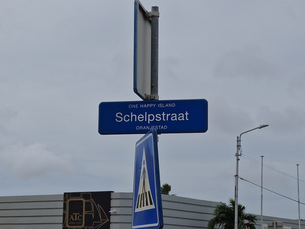 A street sign and international pedestrian-crossing road sign in Oranjestad, Aruba