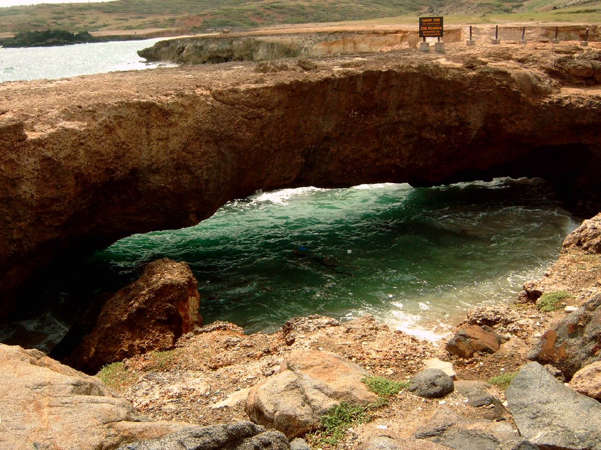 A natural limestone arch over churning water on Aruba's rugged north coast